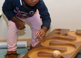 Children practicing balance and coordination through a Montessori walking on the line activity.