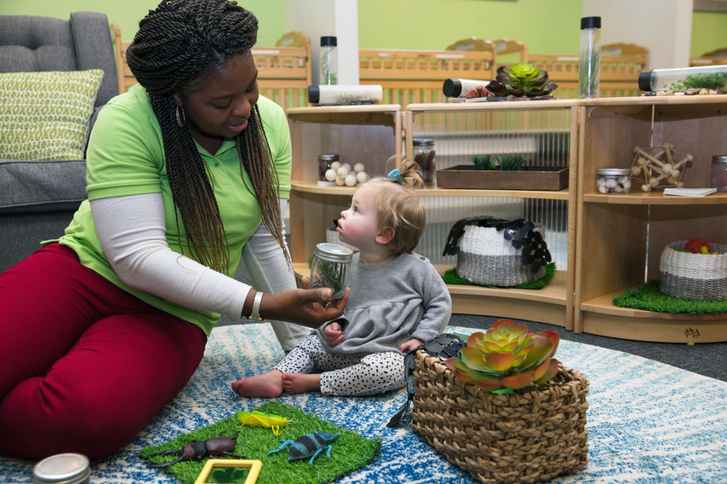 A child using Montessori knobbed cylinders to practice size recognition and fine motor skills.